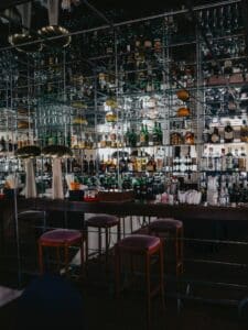 Stylish bar with colourful bottles and mirror