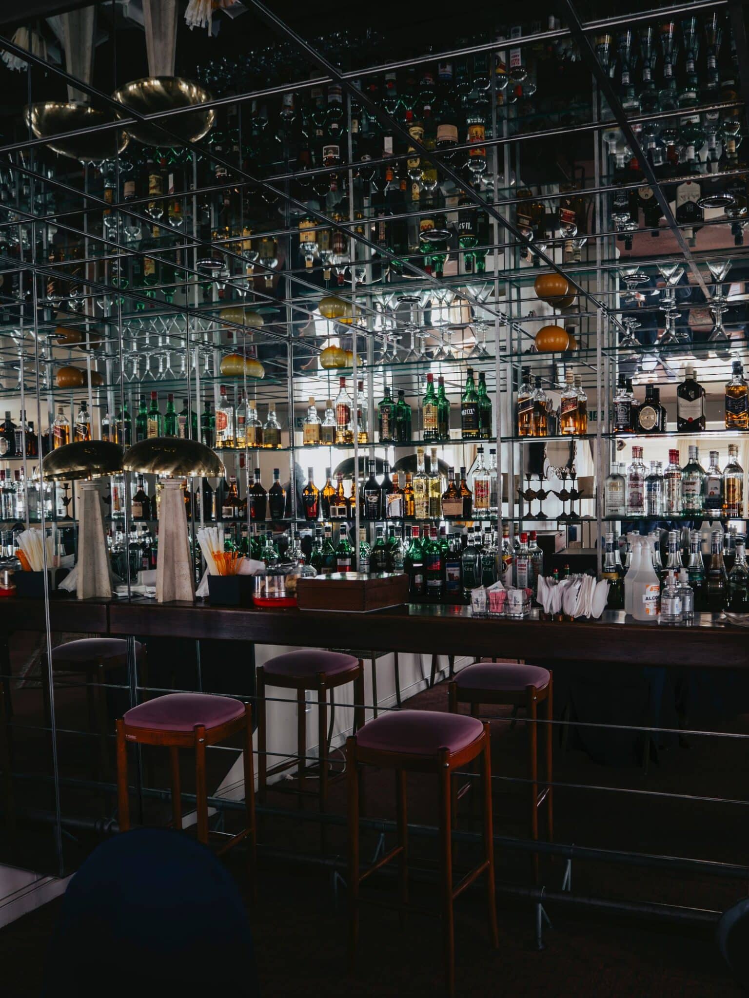 Stylish bar with colourful bottles and mirror