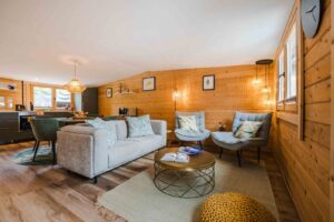 Ferienhaus Chalet Oz in Vitznau am Vierwaldstättersee. Offenes Wohnzimmer und Küche im Chalet Oz in Vitznau mit Holzwänden und gemütlichen Sitzgelegenheiten.