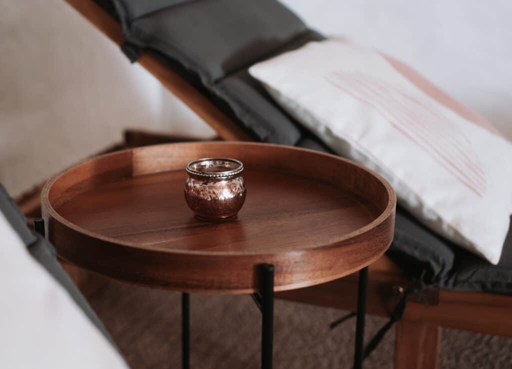 Ruheraum der Harmony Wellness Suite in Vitznau mit hölzernem Beistelltisch, Kerzenhalter und Liegen